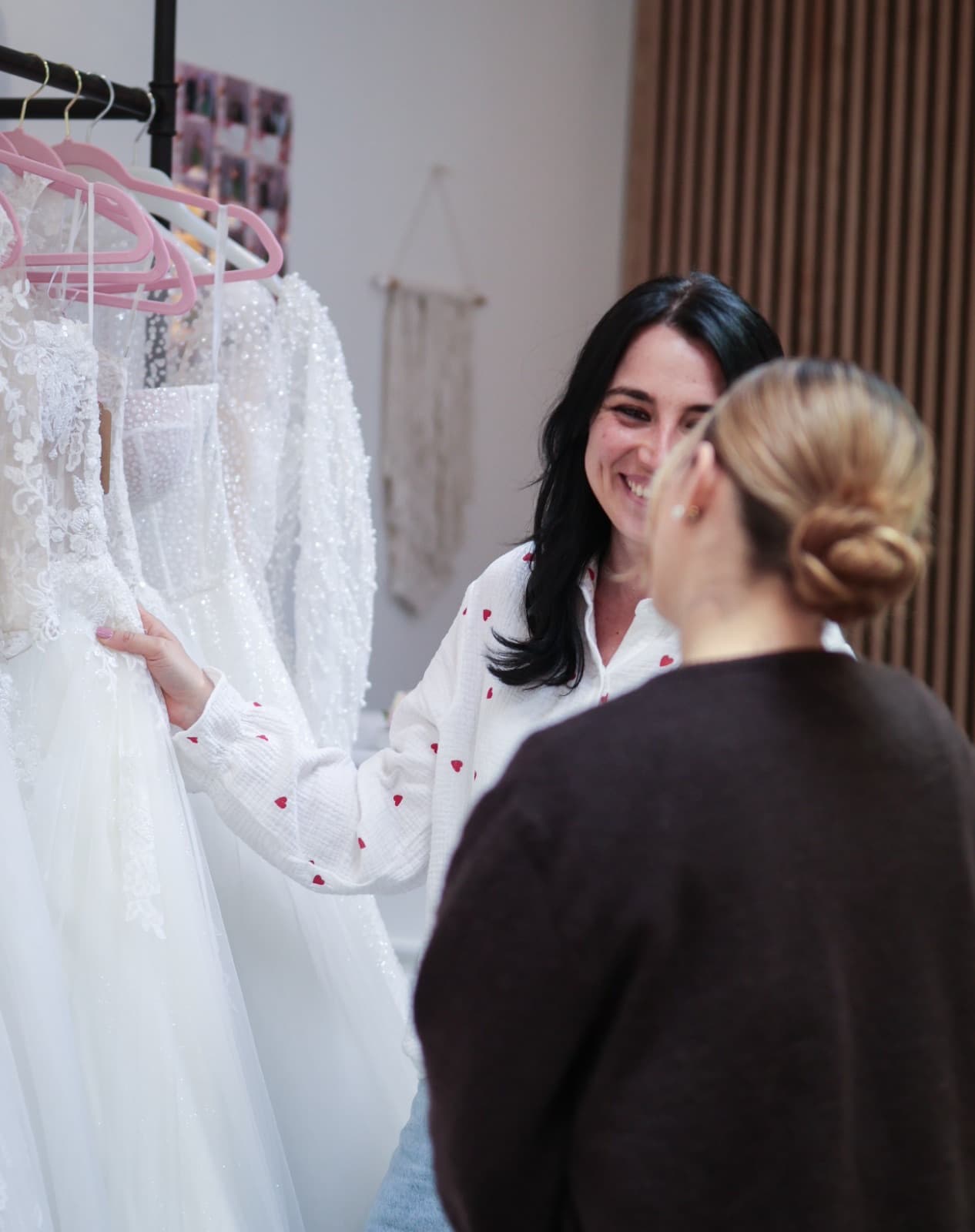 Inhaberin Melanie Pfefferkorn zeigt einer Kundin Brautkleider an der Kleiderstange im Atelier Liebesgeschichte in Königsbach-Stein