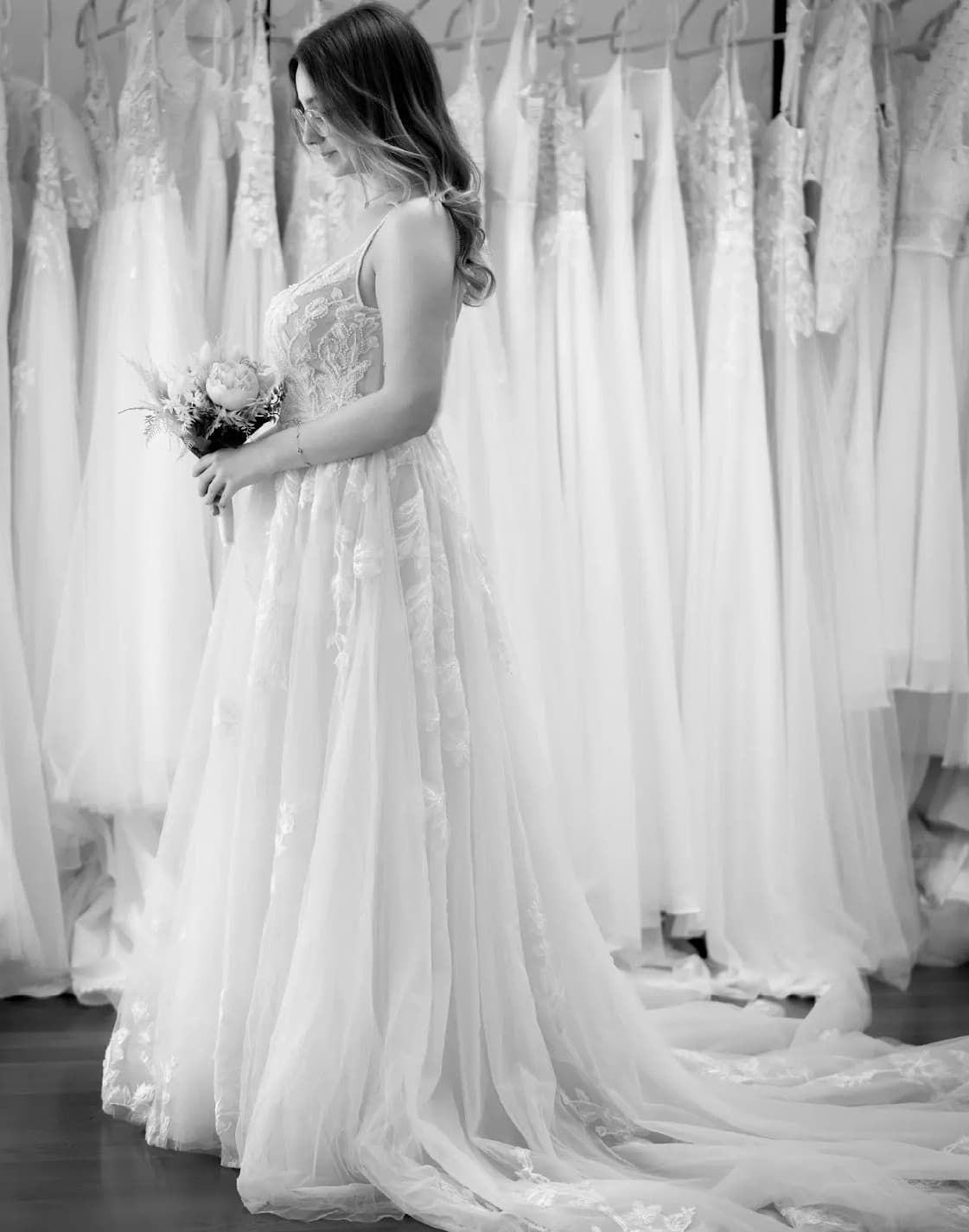 Brautkleid-Anprobe mit Strauß — Schwarz-Weiß-Aufnahme im Atelier Liebesgeschichte