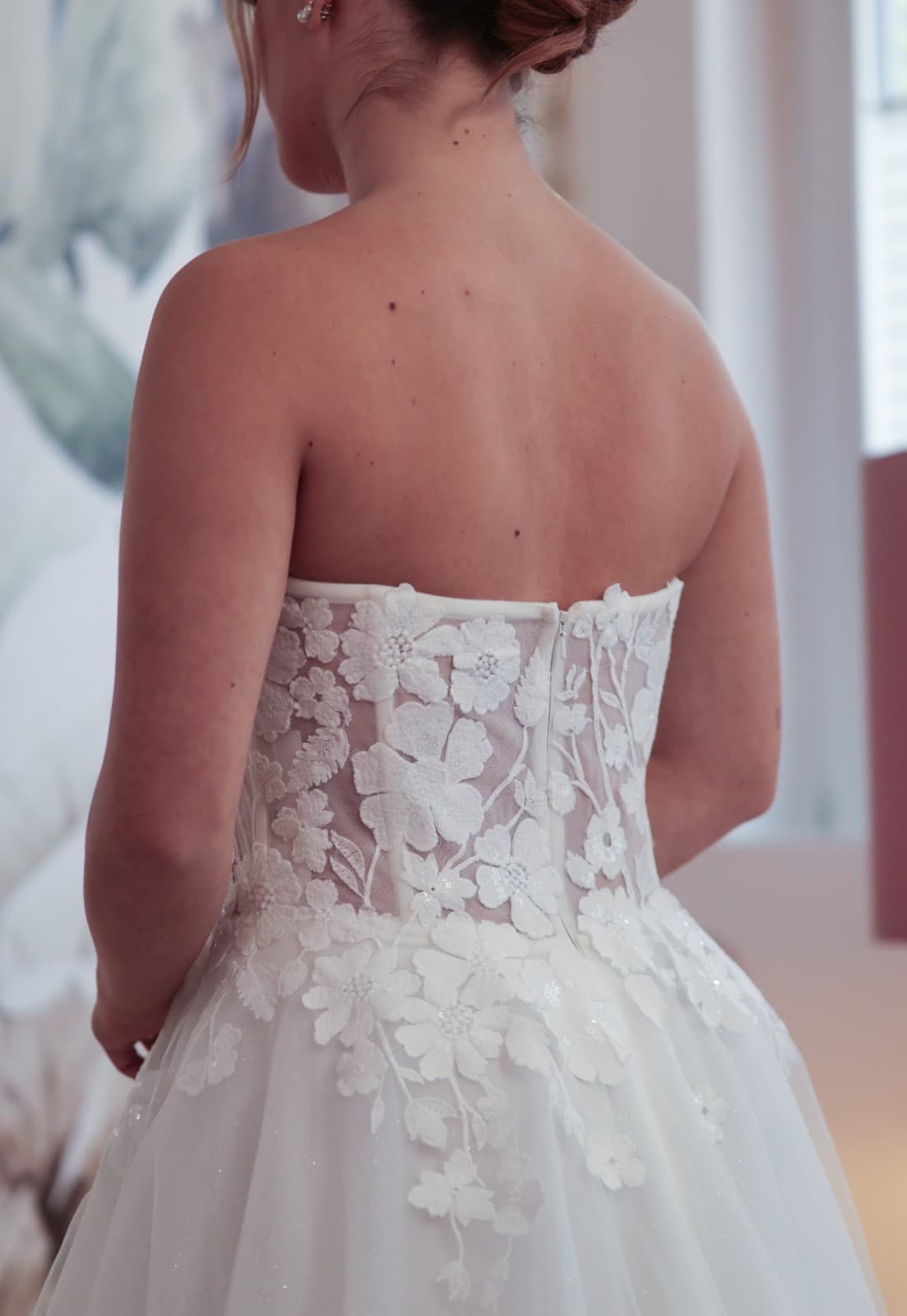 Rückenansicht eines Brautkleids mit floraler Spitze und Korsett-Detail — Outlet Liebesgeschichte