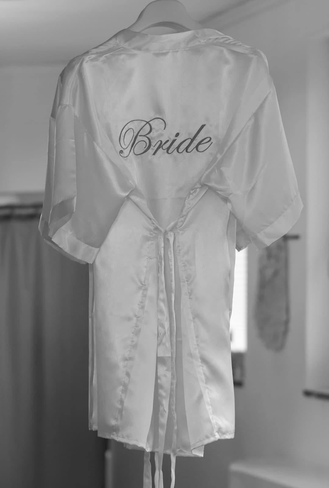 Eleganter Satin-Morgenmantel mit Bride-Schriftzug — Hochzeitsvorbereitung bei Liebesgeschichte