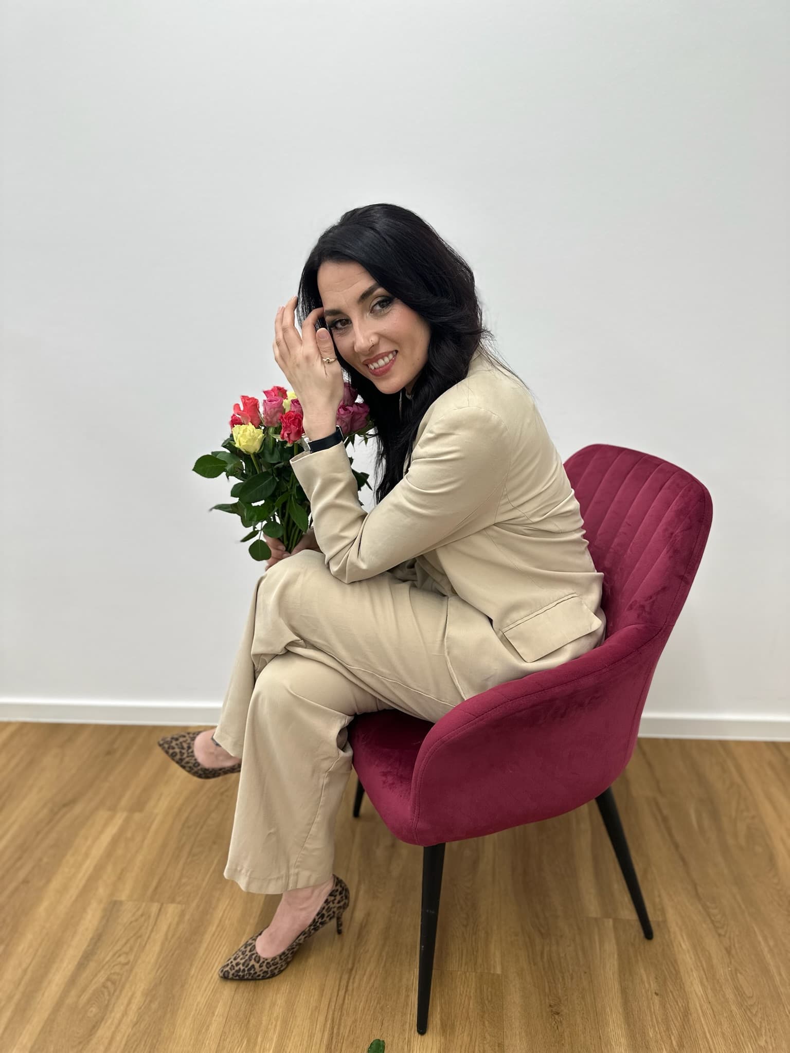 Melanie Pfefferkorn sitzt mit Rosenstrauß auf rotem Sessel — Brautmode Liebesgeschichte Königsbach-Stein