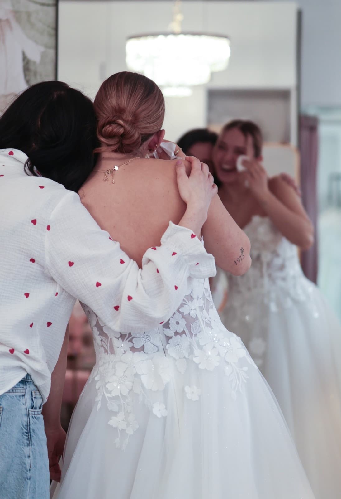 Emotionale Umarmung zwischen Braut und Inhaberin nach dem Brautkleid-Moment bei Liebesgeschichte