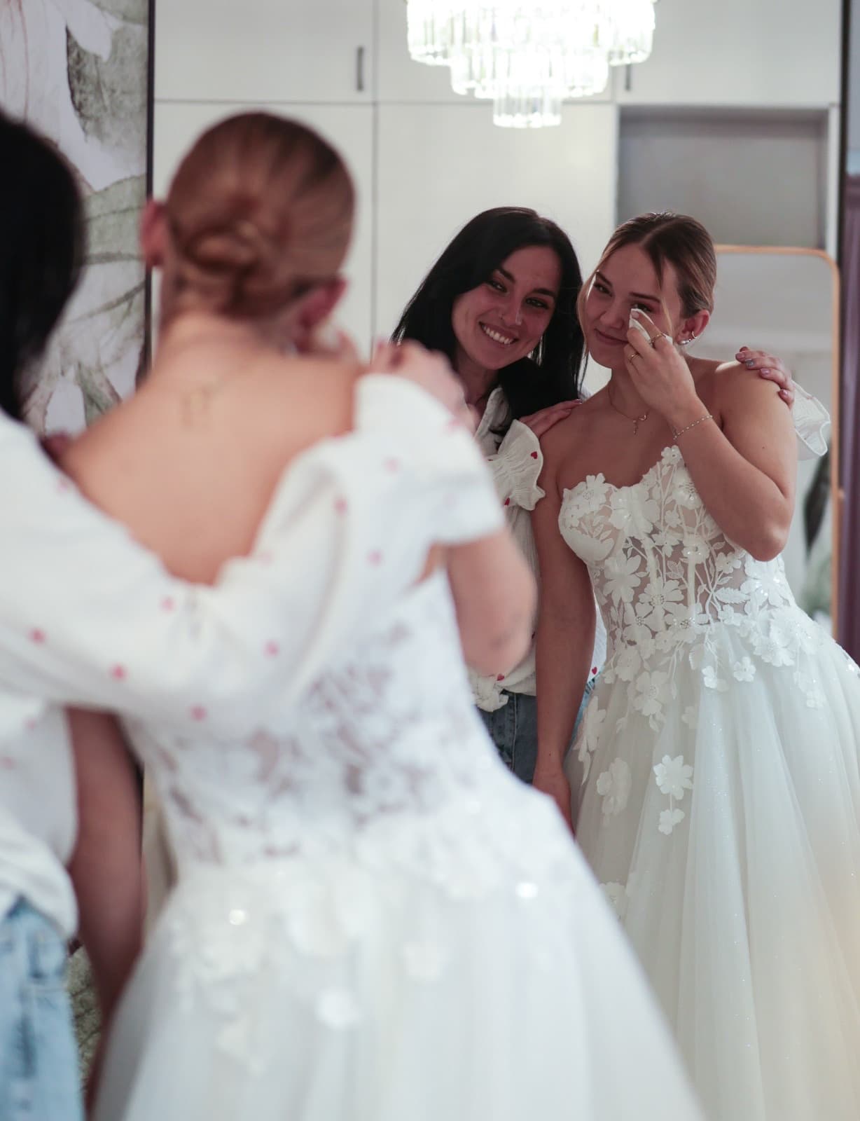 Emotionaler Moment — Braut und Beraterin vor dem Spiegel bei der Brautkleid-Anprobe