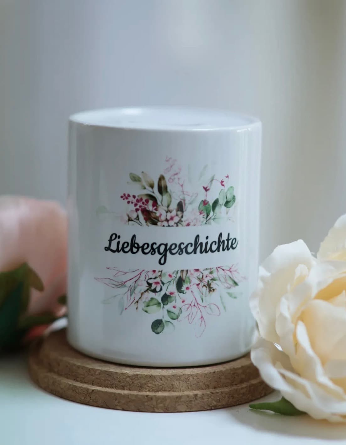 Liebevoll gestaltete Dekoration mit Liebesgeschichte-Kerze und Rosenblüten im Brautmodegeschäft